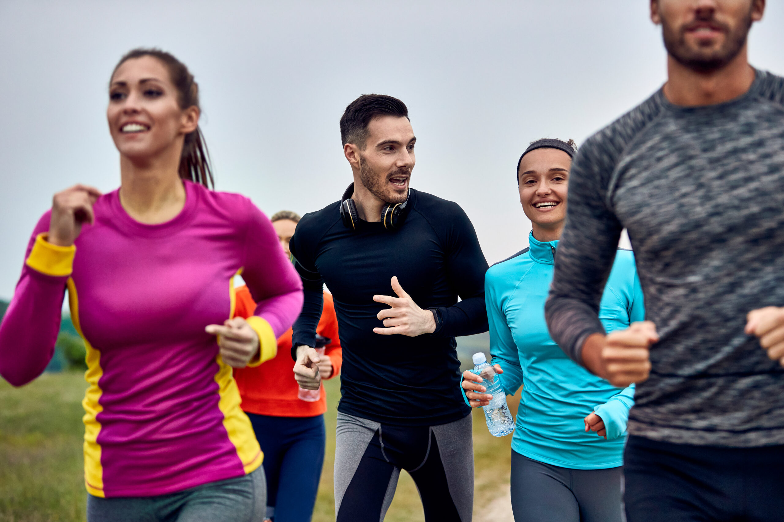 Young happy athletic couple running marathon an talking to each other.